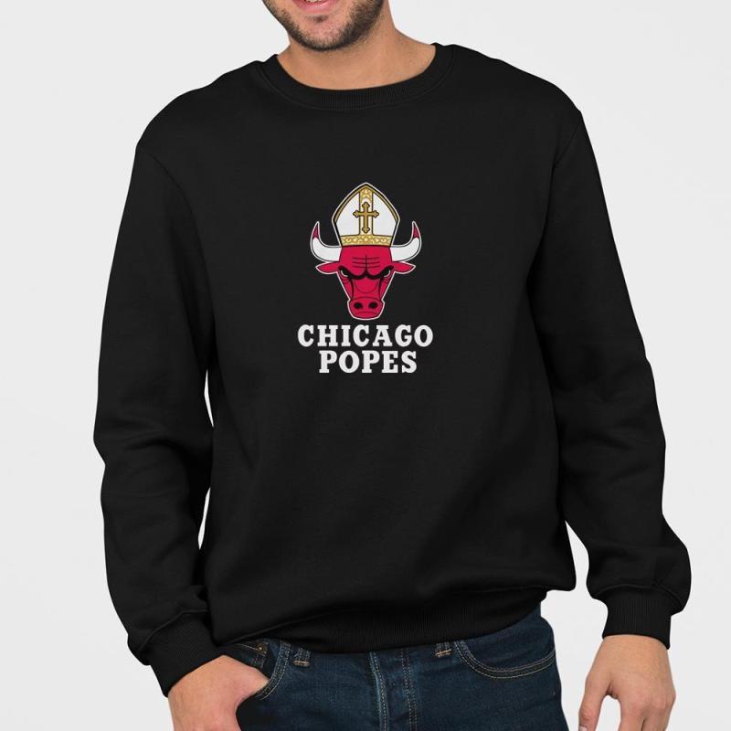 A man wearing a black sweatshirt that says chicago popes.