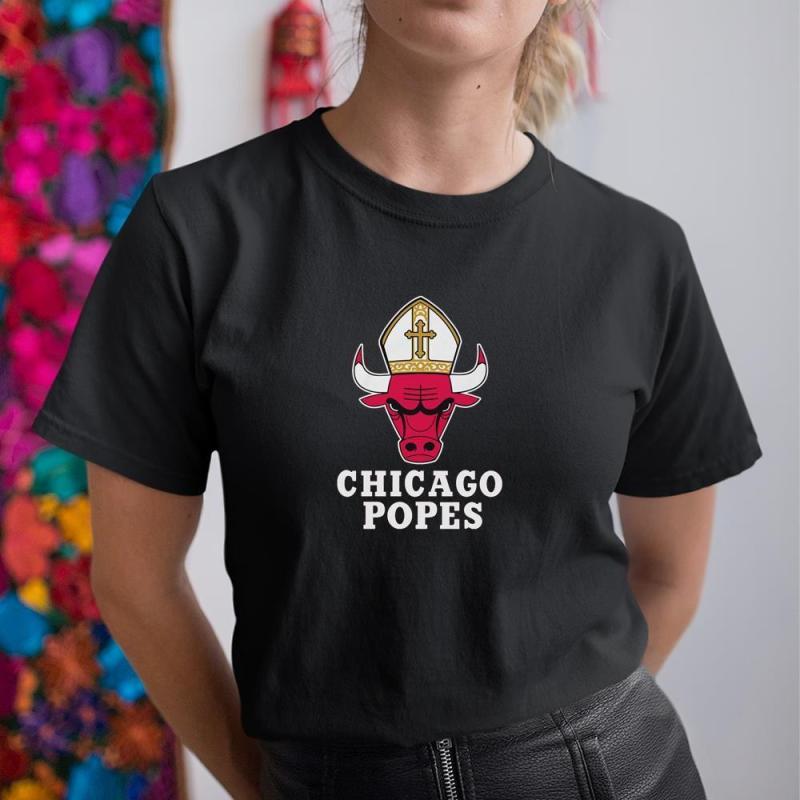 A woman wearing a black shirt that says chicago popes.