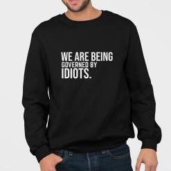 A man wearing a black sweatshirt that says we are being governed by idiots.