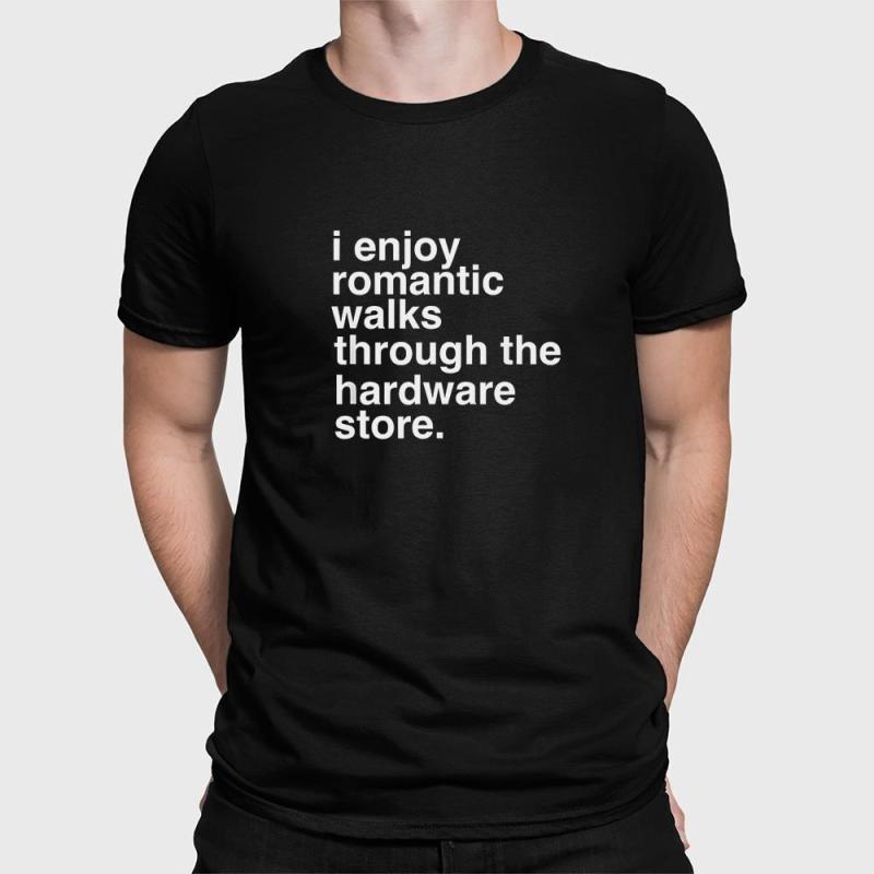 A man wearing a black shirt that says i enjoy romantic walks through the hardware store.