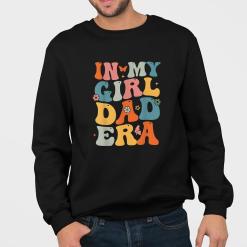 A man wearing a black sweatshirt that says in my girl dad era.