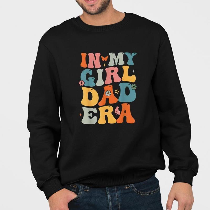 A man wearing a black sweatshirt that says in my girl dad era.