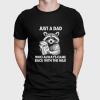 A man wearing a black shirt that says just a dad who always came back with the milk.