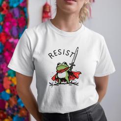 A woman wearing a white shirt with a frog holding a sword.