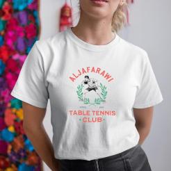 A woman wearing a white shirt that says aljafarawi table tennis club.