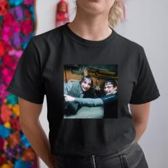 A woman wearing a black t-shirt with a photo of a man and a woman.