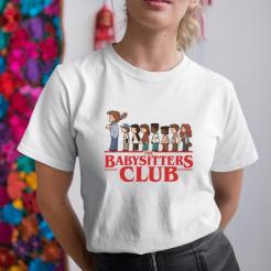 A woman wearing a white shirt that says the babysitters club.